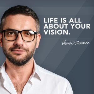 Man with dark hair, white shirt and glasses with caption "Life is all about your vision".